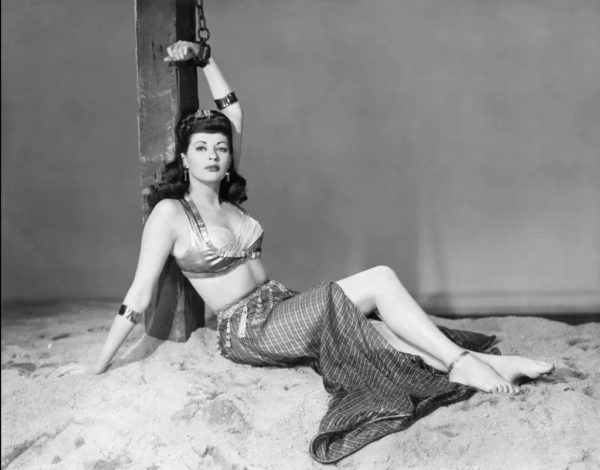 Photo of Yvonne DeCarlo reclining in an exotic slave girl costume